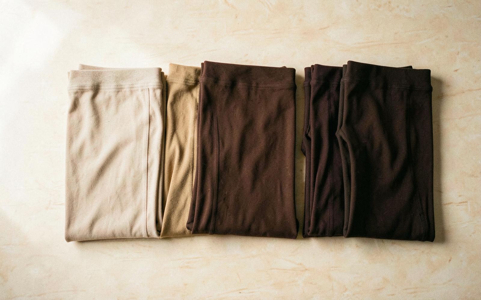 Seven Piel shades of seamless leggings folded in a row, Arena to Ébano